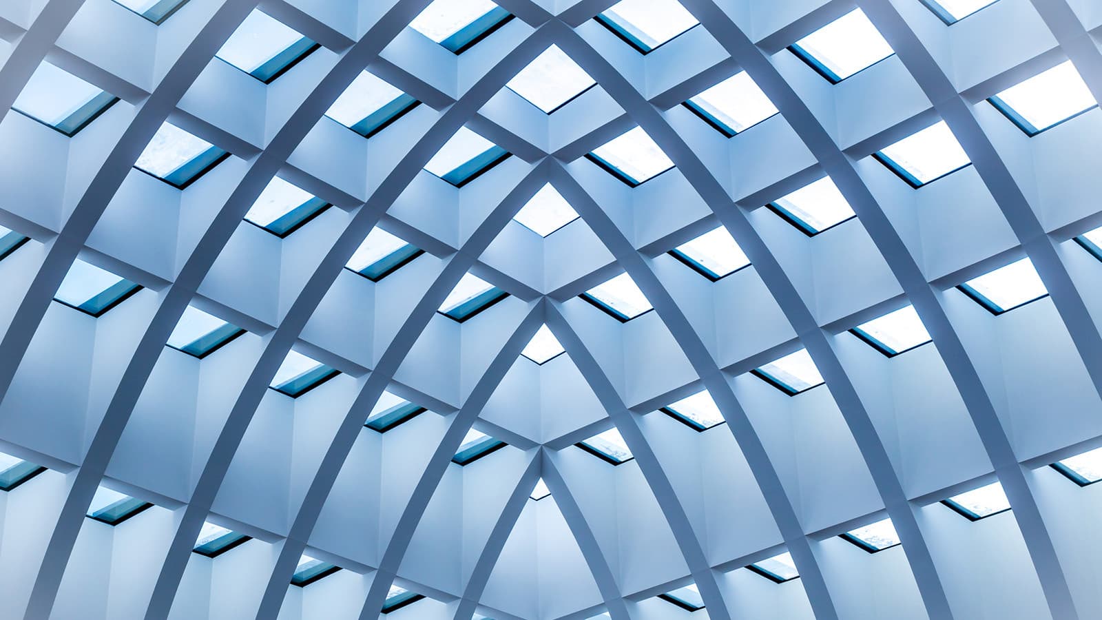 Low-angle view of a patterned blue ceiling with light coming through.