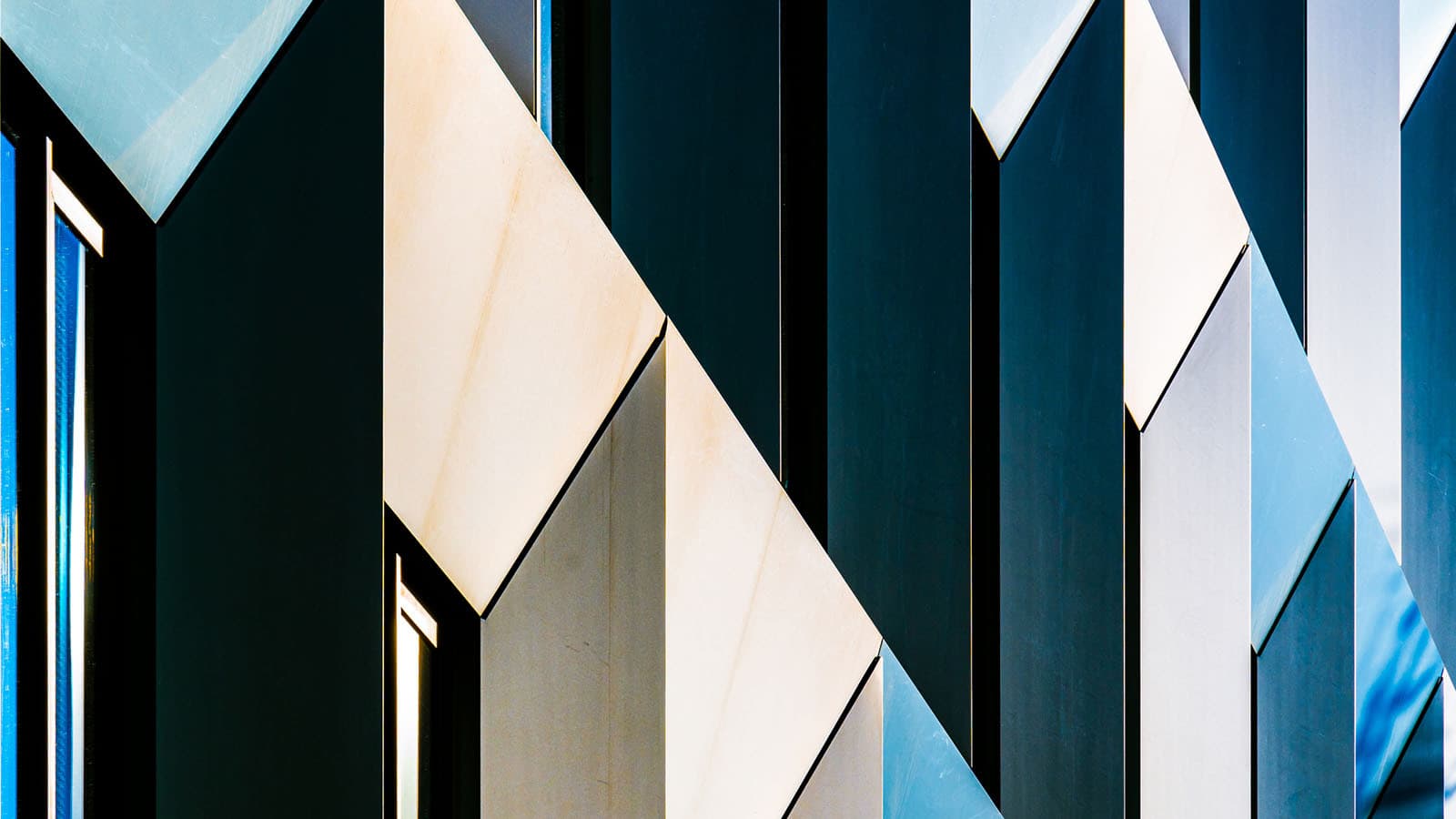 Architectural facade with blue-beige angular geometric patterns.